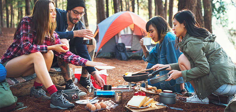 Friends camp in the forest and use reusable crockery