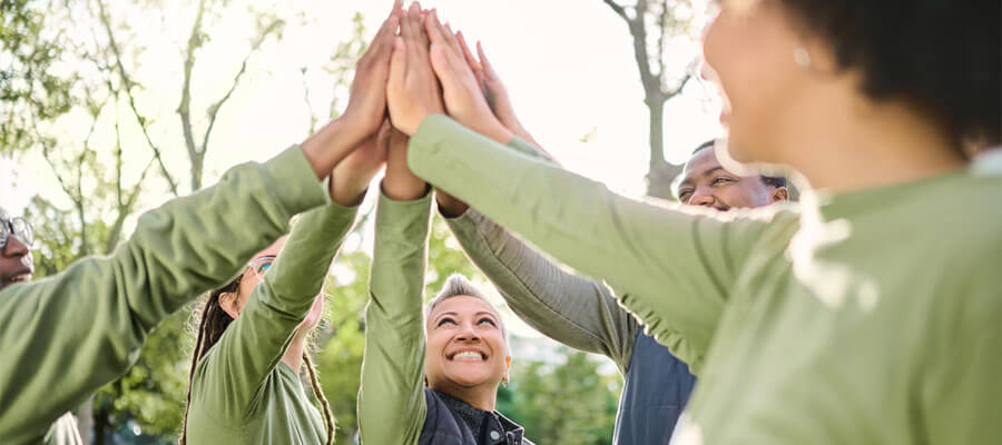 High five, nature and people hands from team building at wellness retreat with community and support. Volunteer, happiness and smile of support group excited with collaboration, trust and solidarity.